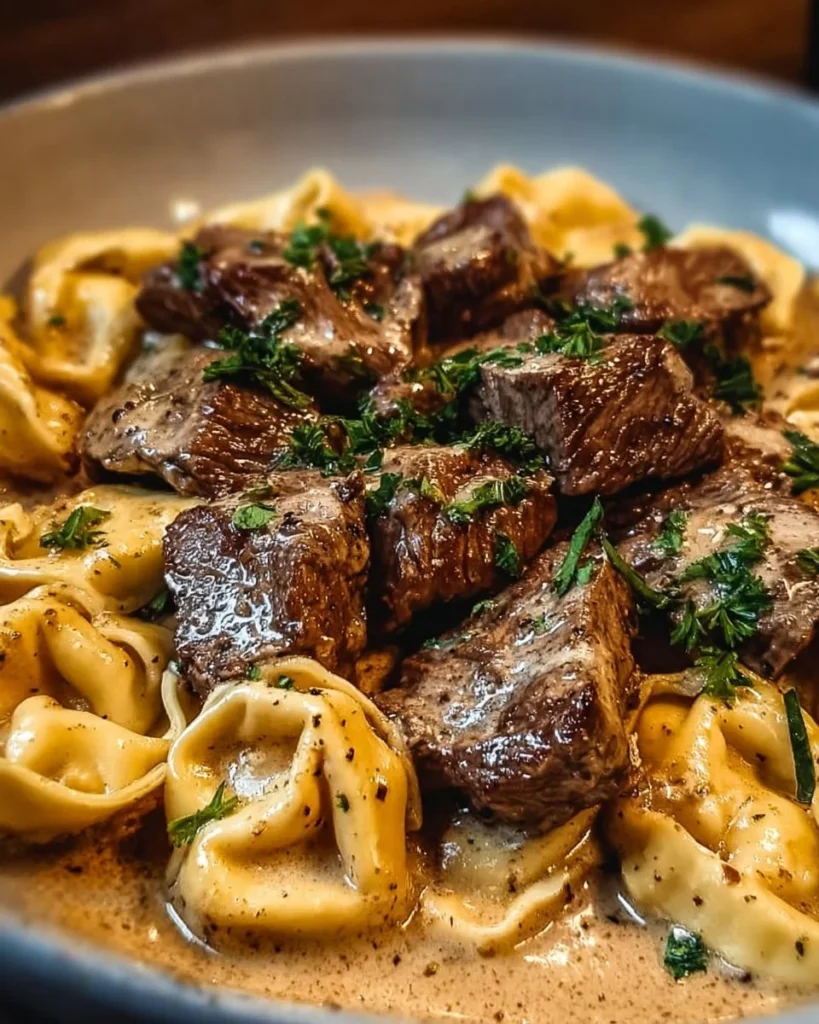 Cracked Garlic Steak Tortellini served in a creamy sauce garnished with herbs.