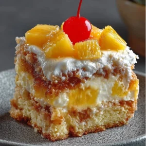 Slice of Hawaiian Pineapple Cake topped with fresh pineapple and whipped cream
