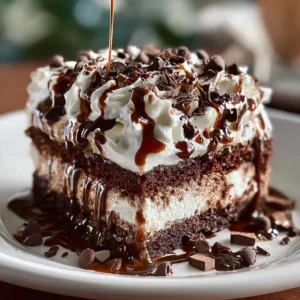 Delicious Marshmallow Chocolate Poke Cake with whipped cream and chocolate drizzle