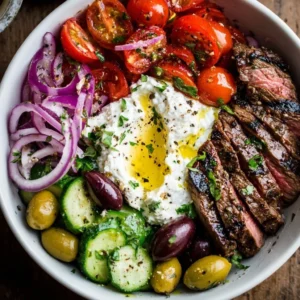 Mediterranean steak bowl with fresh vegetables and flavorful toppings