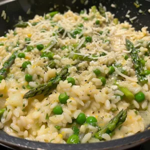 Creamy risotto with colorful spring vegetables in a bowl.