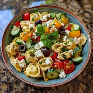 Colorful Greek Tortellini Salad with vegetables and feta cheese in a bowl