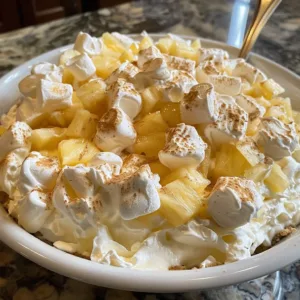 Delicious Pineapple Fluff dessert served in a bowl with fresh pineapple chunks
