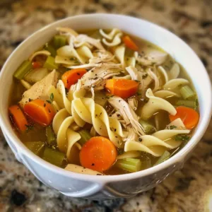 Crockpot Lemon Chicken Noodle Soup in a bowl with lemon slices and parsley